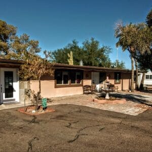 A large brown house with a lot of dirt around it